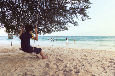 One man stand on the swing at beach to looking anyone play the seaのeditorial素材