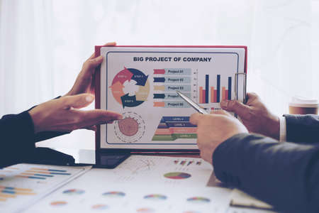 close up hand of marketing manager employee pointing at business document during discussion at meeting room , Notebook on wood table - Business conceptの写真素材