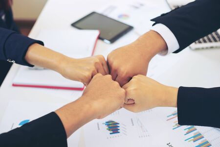 close up hand of business partnership people bump hands thumb up finishing up meeting showing unity...