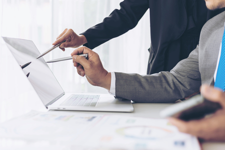 close up hand of marketing manager employee pointing at business document on laptop computer during discussion at meeting room  - Business conceptの写真素材