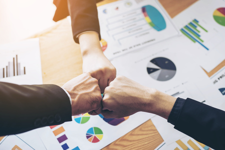 close up hand of business partnership people bump hands  finishing up meeting showing unity over office desk  , business teamwork conceptの写真素材