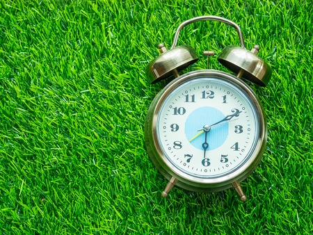 Alarm clock on green lawn
