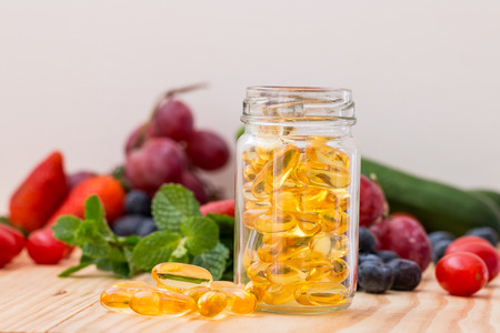 Fish oil, omega 3 with vitamin D capsules good for heart health on a white backguound, healthy diet conceptの写真素材