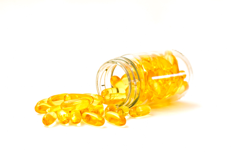 Fish oil, omega 3 with vitamin D capsules good for heart health on a white backguound, healthy diet conceptの写真素材