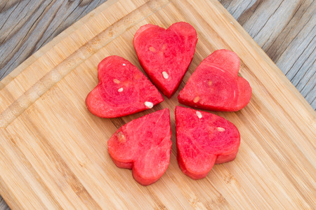 Watermelon heart shaped on wooden background.の写真素材