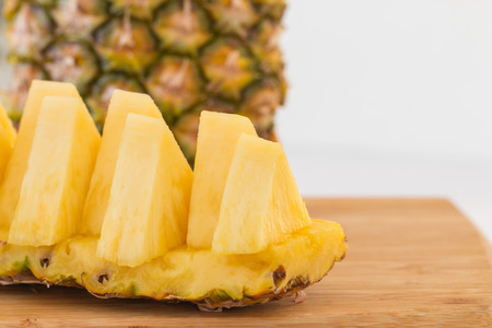 Ripe pineapple sliced on cutting board.の写真素材