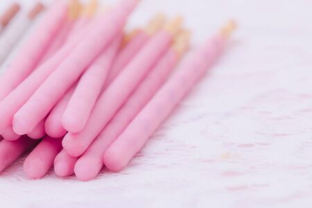 Biscuit sticks covered in  strawberry chocolate flavored and cookies  creamy chocolate flavored on lace background.の写真素材