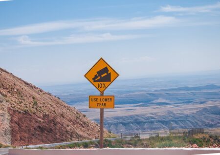 Sign of traffic alerts downhill slope 10 %, reduce speed and use a lower gear. Drive with caution.