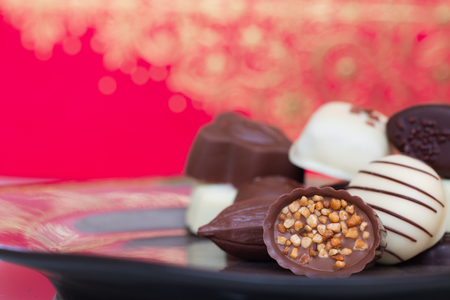 Assorted gourmet chocolate candies in different shapes and colors in the dish.の写真素材