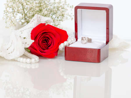 Close up of red rose on white lace and pearls dedorated around.の写真素材
