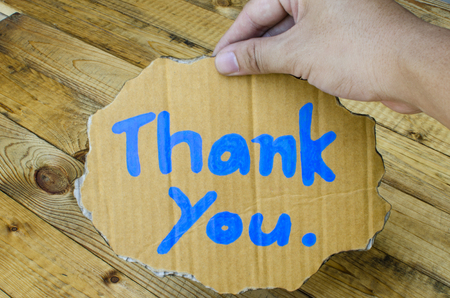 Thank you wording on cardboard on wooden backgroundの写真素材