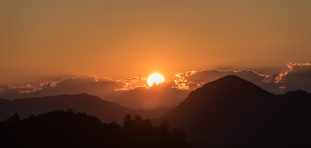 Sun Rise with orange sky and silhouettes mountainの写真素材