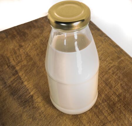 Bottle pf milk on wood plateの写真素材