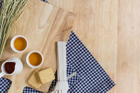 Wood Texture Background Decorated by Cutting Plate, Cups of Tea, and Biscuitsの写真素材