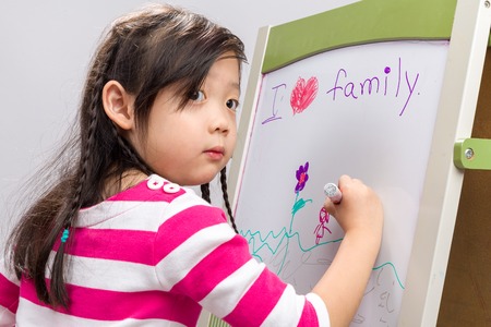Child Drawing on Whiteboard Backgroundの写真素材