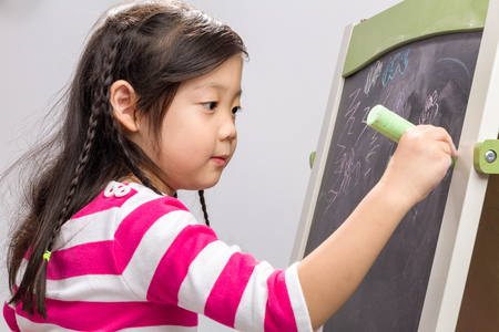 Child Writing on Blackboard Backgroundの写真素材