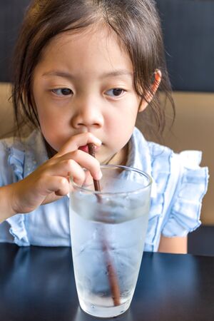 Asian Child Drinking Water from Glassの写真素材