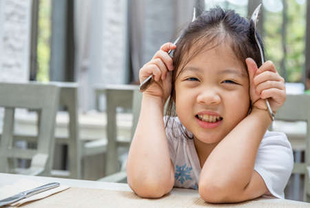 Child Holding Spoon and Forkの写真素材