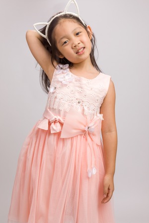 Child with Cat Ear Headband in Pink Dress, Isolated on Whiteの写真素材