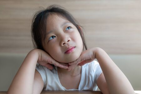 Imagination Concept Illustrated by Asian Child, Girl, Thinking and Looking Up to Skyの写真素材