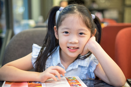 Happy Child, Girl, Sitting at Restaurant and Smileの写真素材