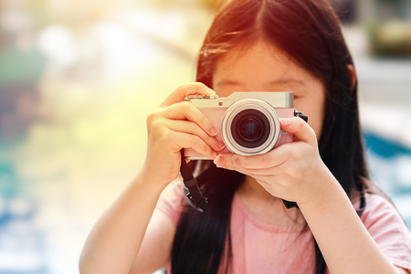 Asian Child Holding Camera Taking Photo Illustrating Travelling Conceptの写真素材