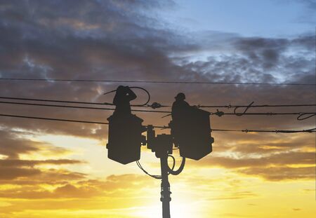 silhouette maintenance of electricians work with high voltage electricity on the hydraulic bucketの写真素材