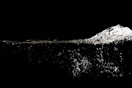 close up of water waves splash and bubbles isolated on black background.の写真素材