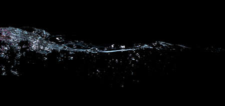 water waves splash and bubbles isolated on black backgroundの写真素材