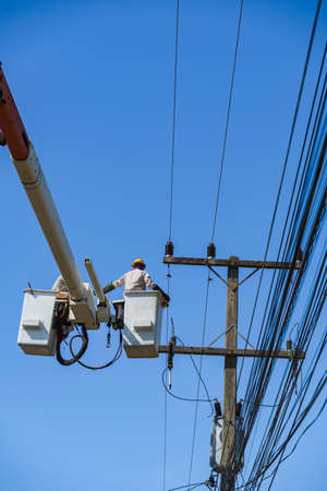 maintenance of electricians work with high voltage electricity on the hydraulic bucket with...