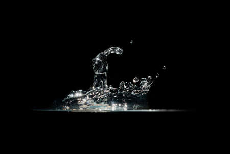 Splashing water on  dark backgroundの写真素材