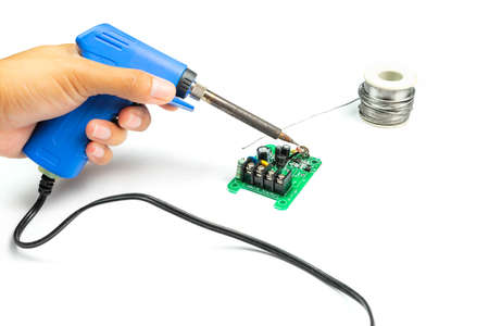 close up hand on  Soldering electronic board on white