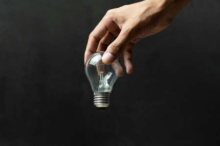Light bulb and hand concept on black background
