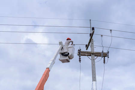 electrician works on cable car to maintain high voltage transmission lines.の写真素材