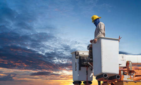 electricians work with high voltage electricity on the hydraulic bucketの写真素材