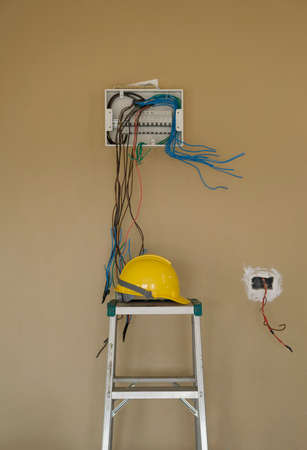 Install box circuit breaker board wiring electric on wall background and safety helmet