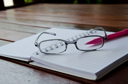 eyeglasses on notebook on tableの写真素材