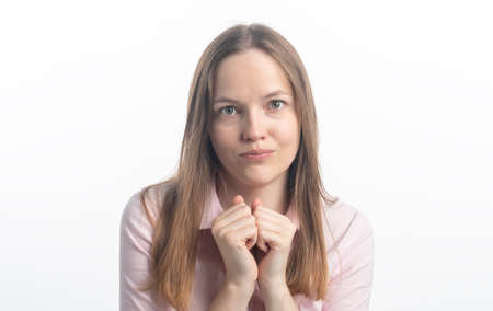 asking and praying for help female, looks with big hope at camera, keeps palms together, asks for forgiveness as betrayed boyfriend, feels guilty. Helpless young woman prays, studio shotの写真素材