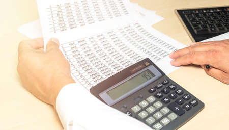A businessman doing some paperwork using his calculator, workplace