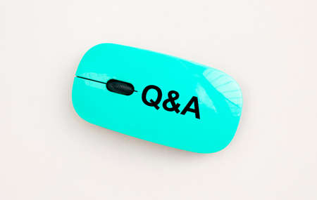 Q and A word acronym on computer mouse on white table, questions and answers conceptの写真素材