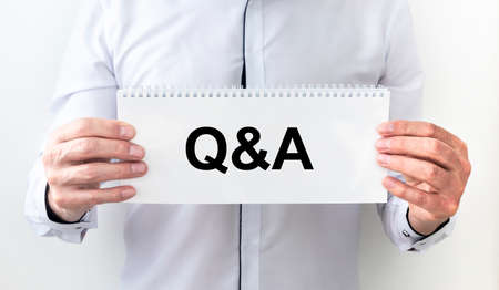 Q and A - Questions and Answers - sign on paper shown by a businessman, white backgroundの写真素材