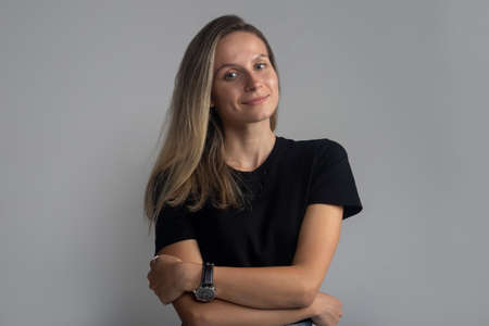 Beautiful young smiling friendly and confident woman portrait looking at camera calmly with crossed...