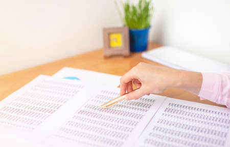 accountant or banker making calculations sitting at office table with documents with tables on desk...