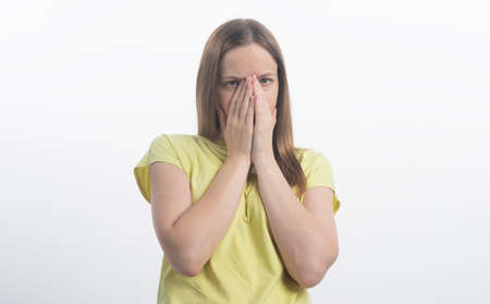 Shocking news. Surprised and calm woman covers her mouth, close-up, isolated on a white background, woman pretending to be shocked and surprisedの写真素材