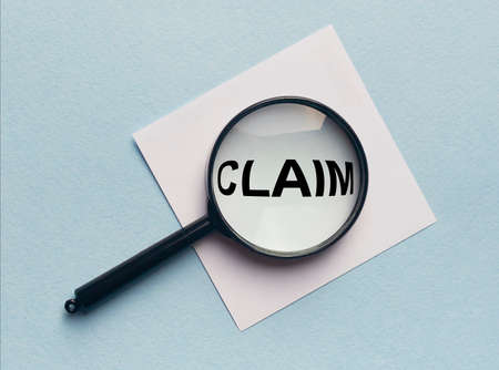 Claim word on paper, lawsuit and claims concept, magnifying glass lensの写真素材