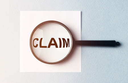 Claim word on paper, lawsuit and claims concept, magnifying glass lensの写真素材