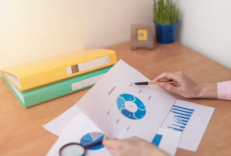 Insurance concept. female hands at office table with blue charts documents, Real Estate concept....