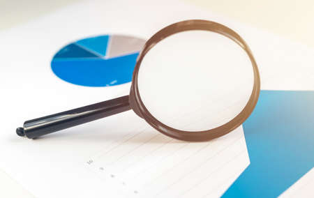 magnifying glass over financial charts diagrams documents, blue colorsの写真素材
