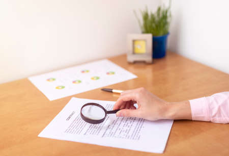 Businesswoman is signing a contract at office table with folders, stamp and contract, signing agreement close upの写真素材