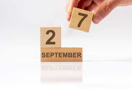 Cube shape calendar for SEPTEMBER 27 on white glossy background with reflection.